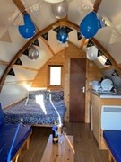 Picture of the inside of one of Herding Hills pods, decorated with ballons and banners